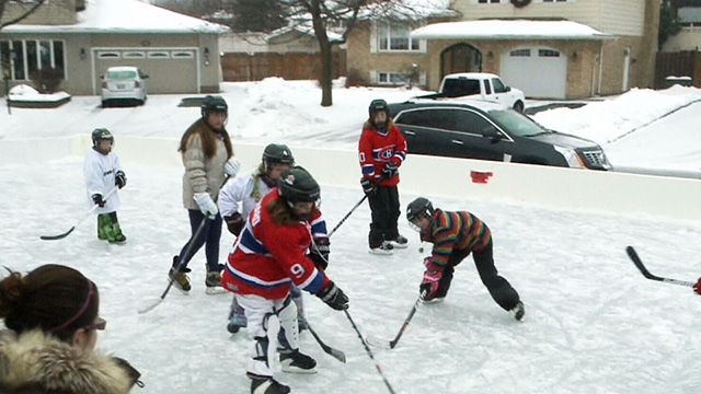 Kids playing hockey in front of the house