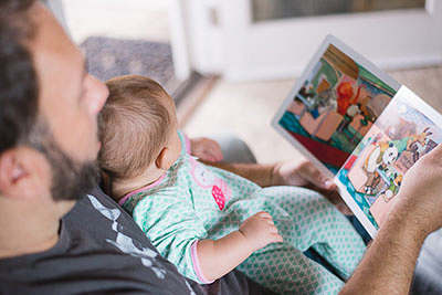 A father reading a book to a baby